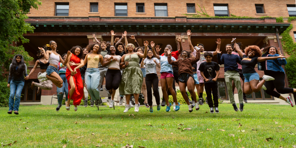 Cornell TASS students jump for joy on the Telluride House lawn